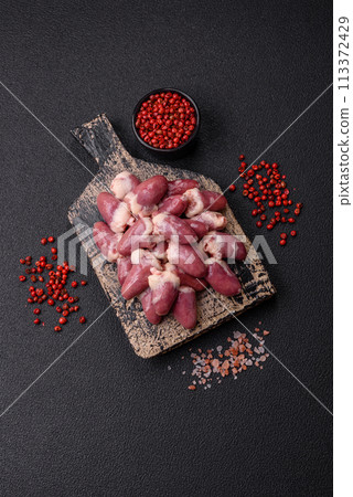Raw chicken hearts with salt, spices and herbs Raw chicken hearts with salt, spices and herbs 113372429