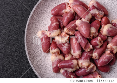 Raw chicken hearts with salt, spices and herbs Raw chicken hearts with salt, spices and herbs 113372442