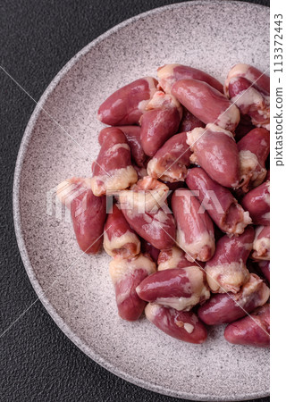 Raw chicken hearts with salt, spices and herbs 113372443