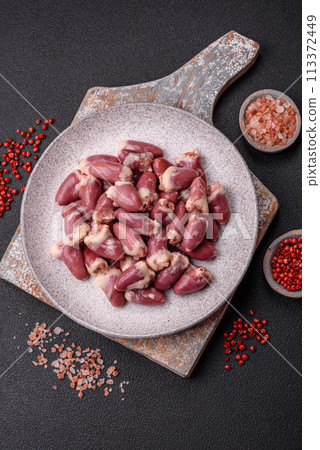 Raw chicken hearts with salt, spices and herbs 113372449