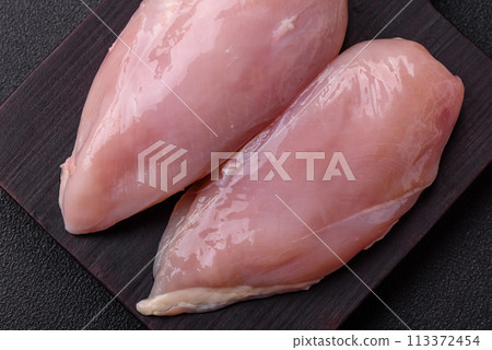 Fresh chicken fillet on a dark concrete table with spices and herbs Fresh chicken fillet on a dark concrete table with spices and herbs 113372454