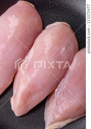 Fresh chicken fillet on a dark concrete table with spices and herbs 113372477