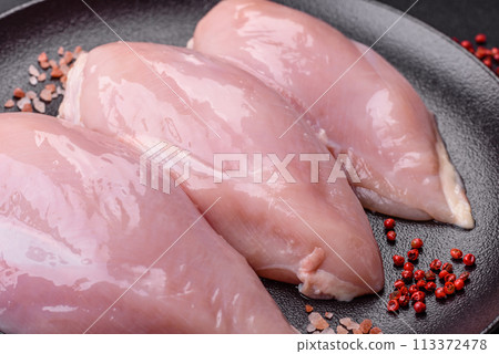 Fresh chicken fillet on a dark concrete table with spices and herbs 113372478