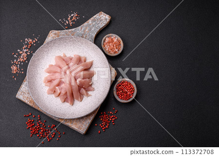 Slices of raw chicken or turkey fillet with salt, spices and herbs Slices of raw chicken or turkey fillet with salt, spices and herbs 113372708