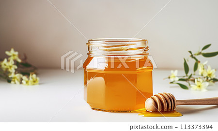 Amber Honey Jar with Wooden Dipper on White Background, Organic Sweetener Amber Honey Jar with Wooden Dipper on White Background, Organic Sweetener 113373394