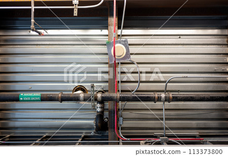 Looking up into an industrial ceiling with overhead sewer water line labeled.  113373800