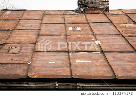 Old rusty metal roof with patches. Repair and renovation 113374178