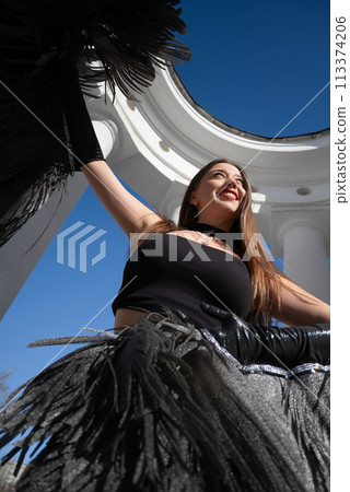 a girl in a black suit and angel wings on the background of the rotunda and the sky 113374206