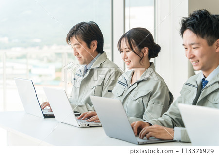 Male and female businessmen and engineers wearing work clothes and workwear doing desk work Male and female businessmen and engineers wearing work clothes and workwear doing desk work 113376929