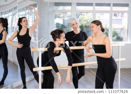 Women students of ballet studio chat sweetly during break, after end of workout. 113377626