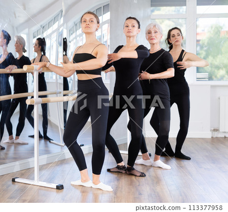 Women in ballet class perform composition with demi plie with participation of mature female mentor 113377958