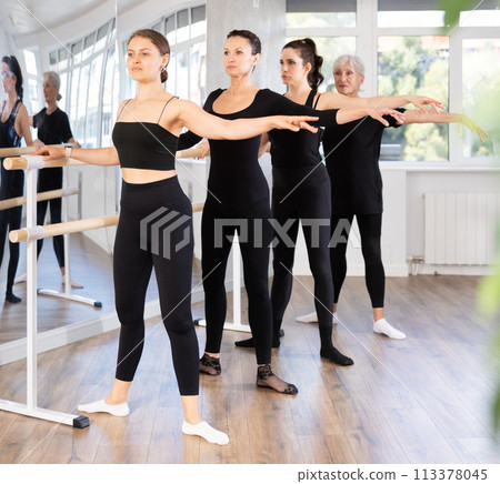 Group of women practicing at ballet barre Group of women practicing at ballet barre 113378045