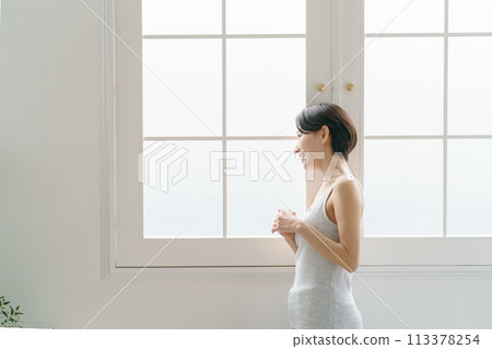 一名30多歲的女子站在窗邊 113378254
