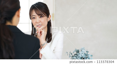 Two businesswomen talking in the office 113378304