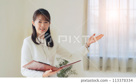 Middle-aged woman guiding the room Middle-aged woman guiding the room 113378334