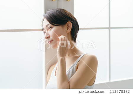A woman in her 30s feels the moisture in her skin 113378382