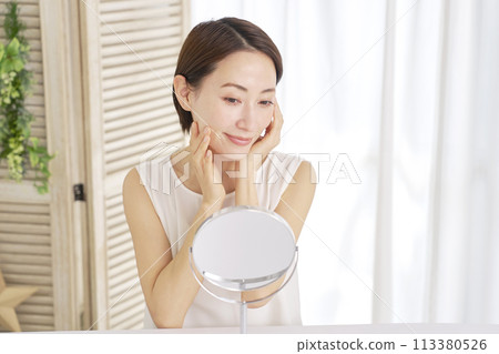 A woman in her 40s doing skin care at home 113380526