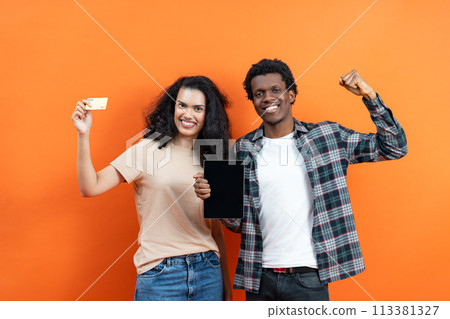 Couple Holding Credit Card and Tablet on Orange Background 113381327