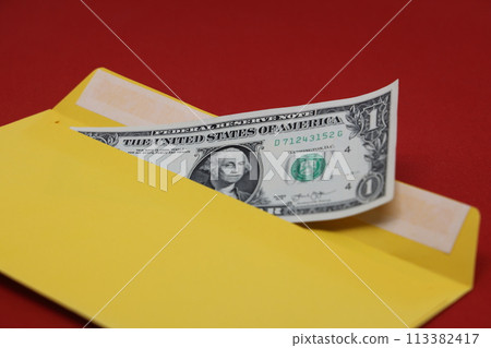 Banknotes in a yellow envelope on a red background. Bribery concept. Salary in envelopes, fraud. 113382417