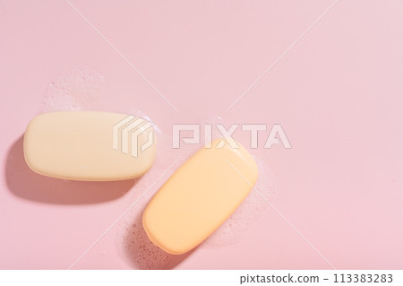 Two bars of soap with foam on a pink background Two bars of soap with foam on a pink background 113383283