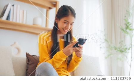 Happy young asian woman relax on comfortable couch at home 113383799