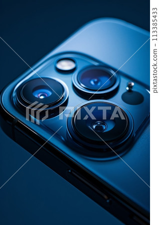 A close-up on a smartphone's camera array, set against a deep navy background 113385433