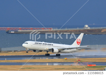 A passenger plane takes off kicking up a cloud of water A passenger plane takes off kicking up a cloud of water 113386015