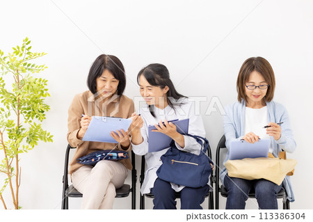 女人在候診室填寫剪貼板 女人在候診室填寫剪貼板 113386304