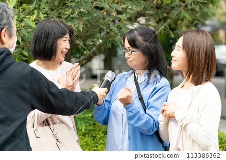 A woman responding to an interview on the street 113386362