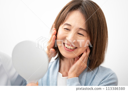 A woman in her 60s trying out cosmetics A woman in her 60s trying out cosmetics 113386380