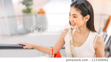 Asian woman standing on escalator with shopping bags in department store city lifestyles 113388062