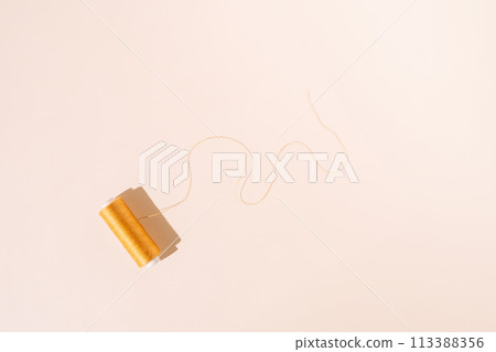 Golden skein of unraveled threads on a white background 113388356