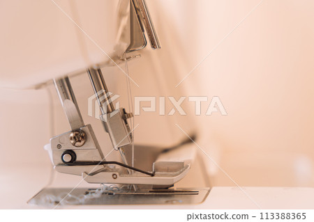 Close-up of a presser foot from an overlock machine 113388365