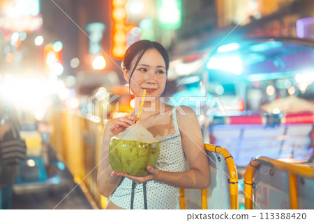 Asian tourist woman eating coconut juicetraveling at China town asia street food night market 113388420