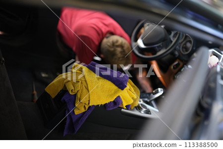 Man cleaning car interior at car wash closeup Man cleaning car interior at car wash closeup 113388500