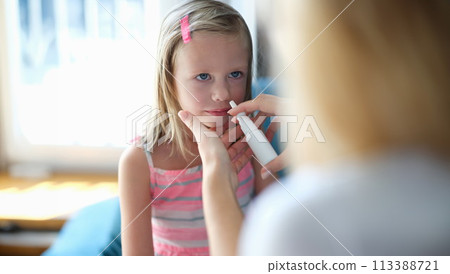 Mother sprinkling nose of little girl with vasoconstrictor drops at home Mother sprinkling nose of little girl with vasoconstrictor drops at home 113388721