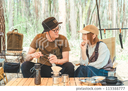 情侶露營者、情侶、男人和女人在露營地用咖啡磨咖啡 113388777