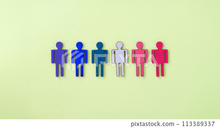 Multi-colored wooden figurines of man on yellow background Multi-colored wooden figurines of man on yellow background 113389337