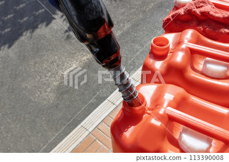 Filling a red plastic tank with kerosene 113390008