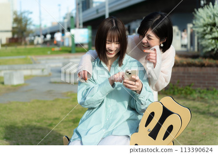 兩個女孩看著智慧型手機 113390624