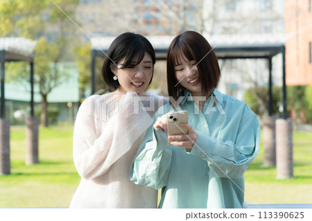 兩個女孩看著智慧型手機 113390625