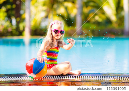 Child in swimming pool with ball. Kids swim. 113391005