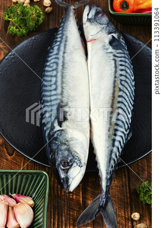 Fresh uncooked mackerel fish on table. Fresh uncooked mackerel fish on table. 113391064