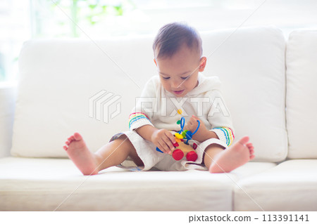 Baby boy playing with toy train 113391141