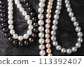 放置在黑色岩石上的一系列珍珠項鍊 113392407