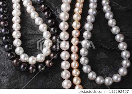 放置在黑色岩石上的一系列珍珠項鍊 113392407