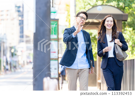 Business men and women walking 113392453