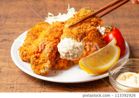 Fried oysters dipped in plenty of tartar sauce 113392926