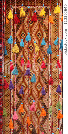 Decorative cords with tassels and traditional iranian carpet in old Grand Bazaar, located in the historical center of the Isfahan, Iran. Tasselled cords on oriental carpet background 113393649