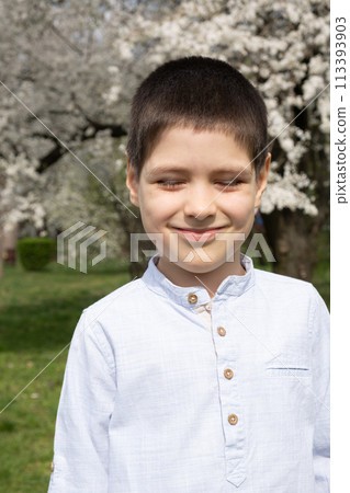 Six-year-old boy squinting in bright afternoon sun. 113393903